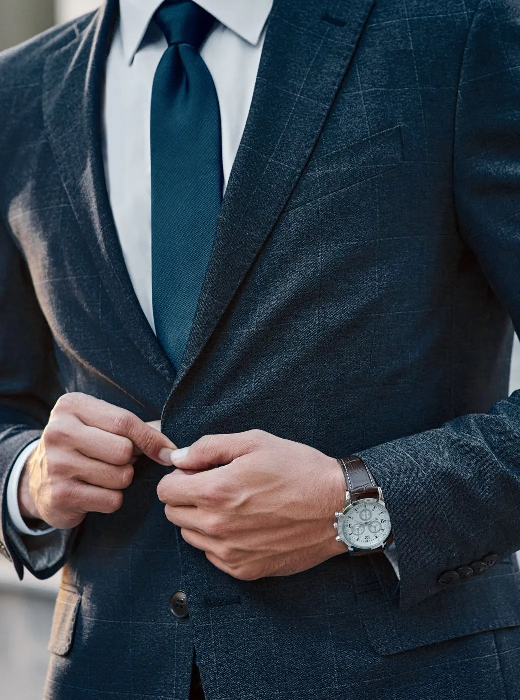 Homme en costume boutonnant sa veste