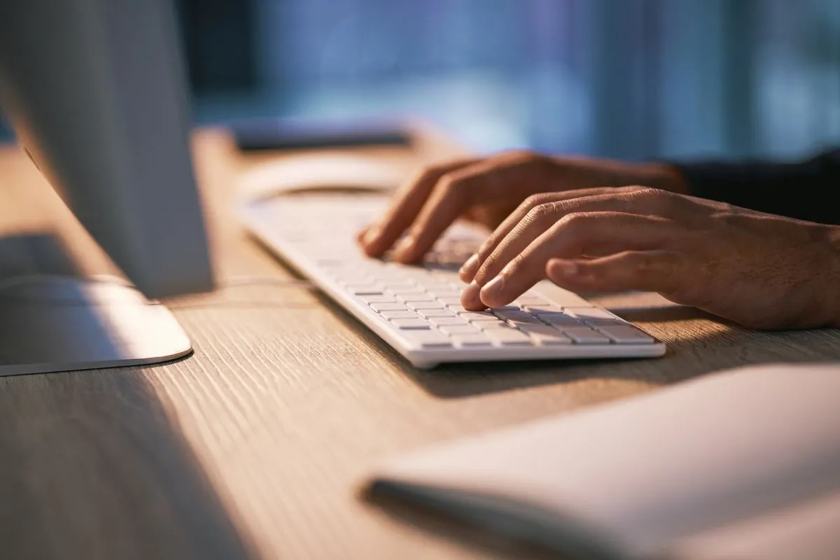 Mains sur un clavier dans un bureau